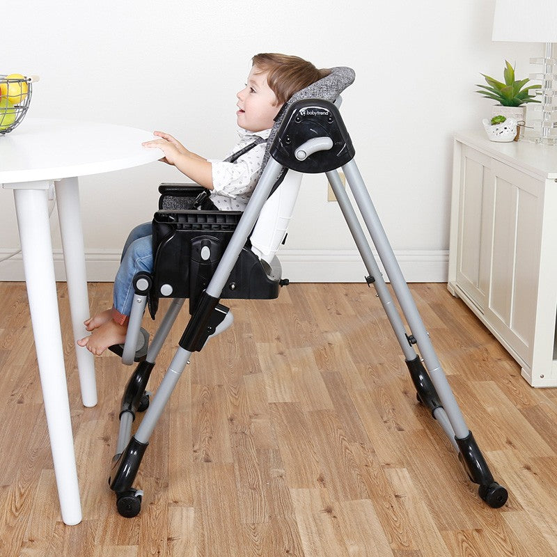 A child sitting at the dining table with the booster mode on the Baby Trend A La Mode Snap Gear 5-in-1 High Chair