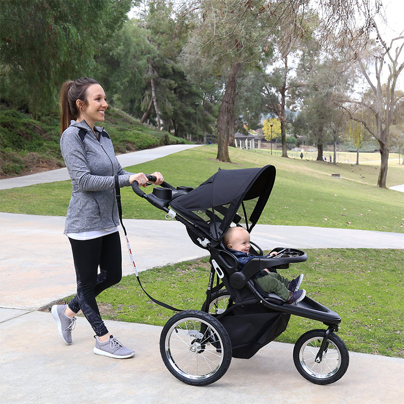 Parent strolling with her child in the Baby Trend Quick Step Jogging Stroller