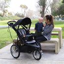 Load image into gallery viewer, Mom is playing with her child in the park with Baby Trend Quick Step Jogging Stroller