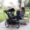 Mom is playing with her child in the park with Baby Trend Quick Step Jogging Stroller