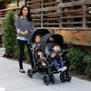 Load image into gallery viewer, Mom is pushing two of her children in the Baby Trend Sit N' Stand Double Stroller