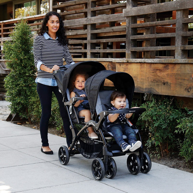 Mom is pushing two of her children in the Baby Trend Sit N' Stand Double Stroller