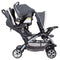 Baby Trend Sit N' Stand Double Stroller with child sitting in front and infant car seat in the back seat